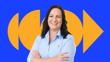 Greater Bank lender standing with arms crossed against a blue and orange background.
