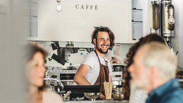 Distant photo of barista smiling at a customer