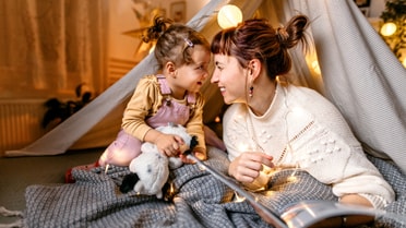Woman and child in TeePee smiling at one another