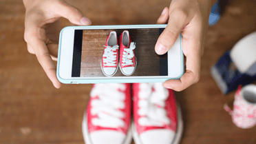 Person with iPhone taking photo of Shoes