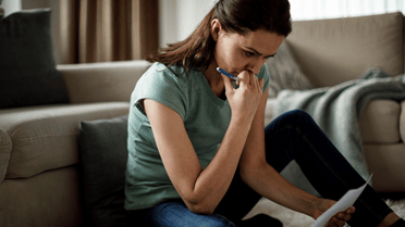 Women on phone with piece of paper concerned