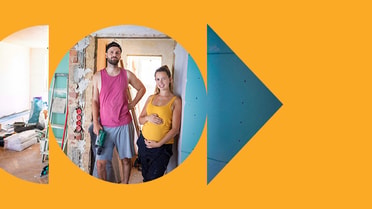 Two people standing inside a house undergoing renovation works.