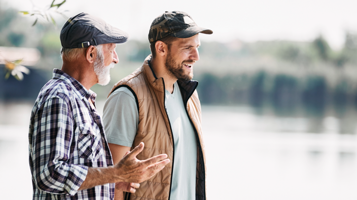 Man and elderly man walking along lake